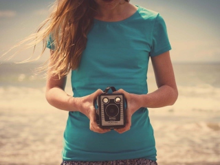 Sfondi Girl On Beach With Retro Camera In Hands 320x240