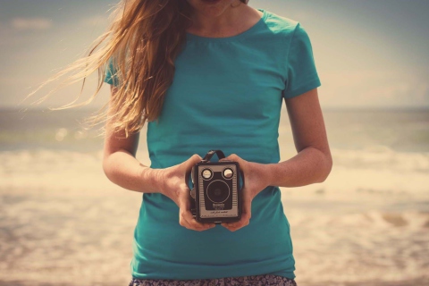 Sfondi Girl On Beach With Retro Camera In Hands 480x320