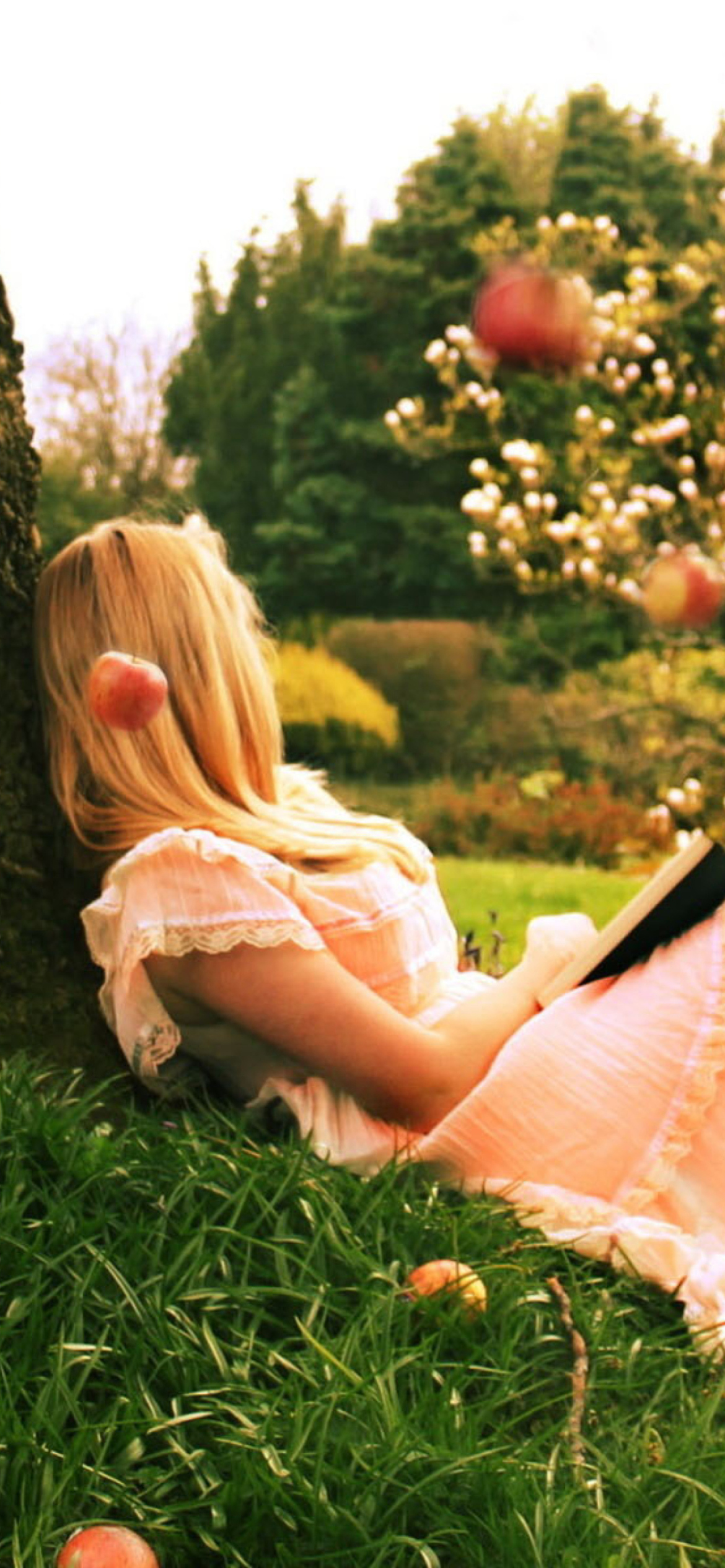 Fondo de pantalla Blonde Girl Reading Book Under Tree 1170x2532