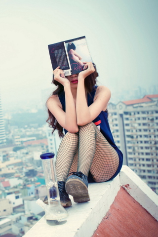 Fondo de pantalla Girl With Book Sitting On Roof 320x480