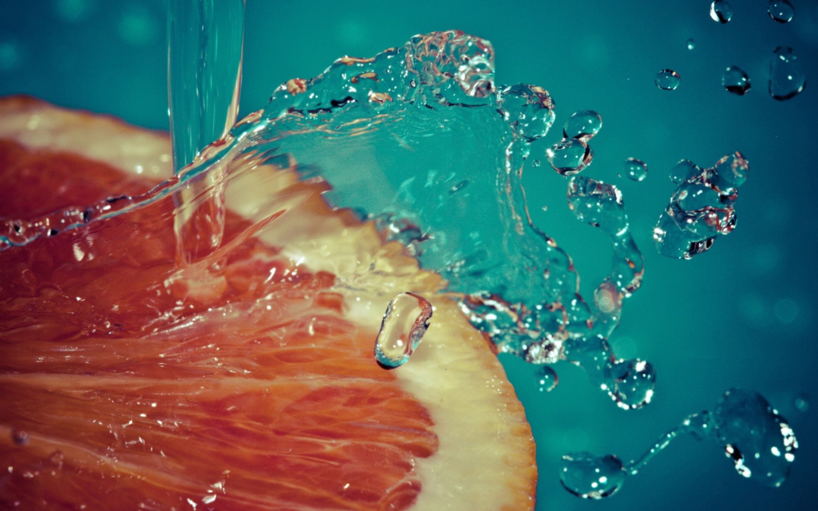 Orange Slice In Water Drops wallpaper 1680x1050