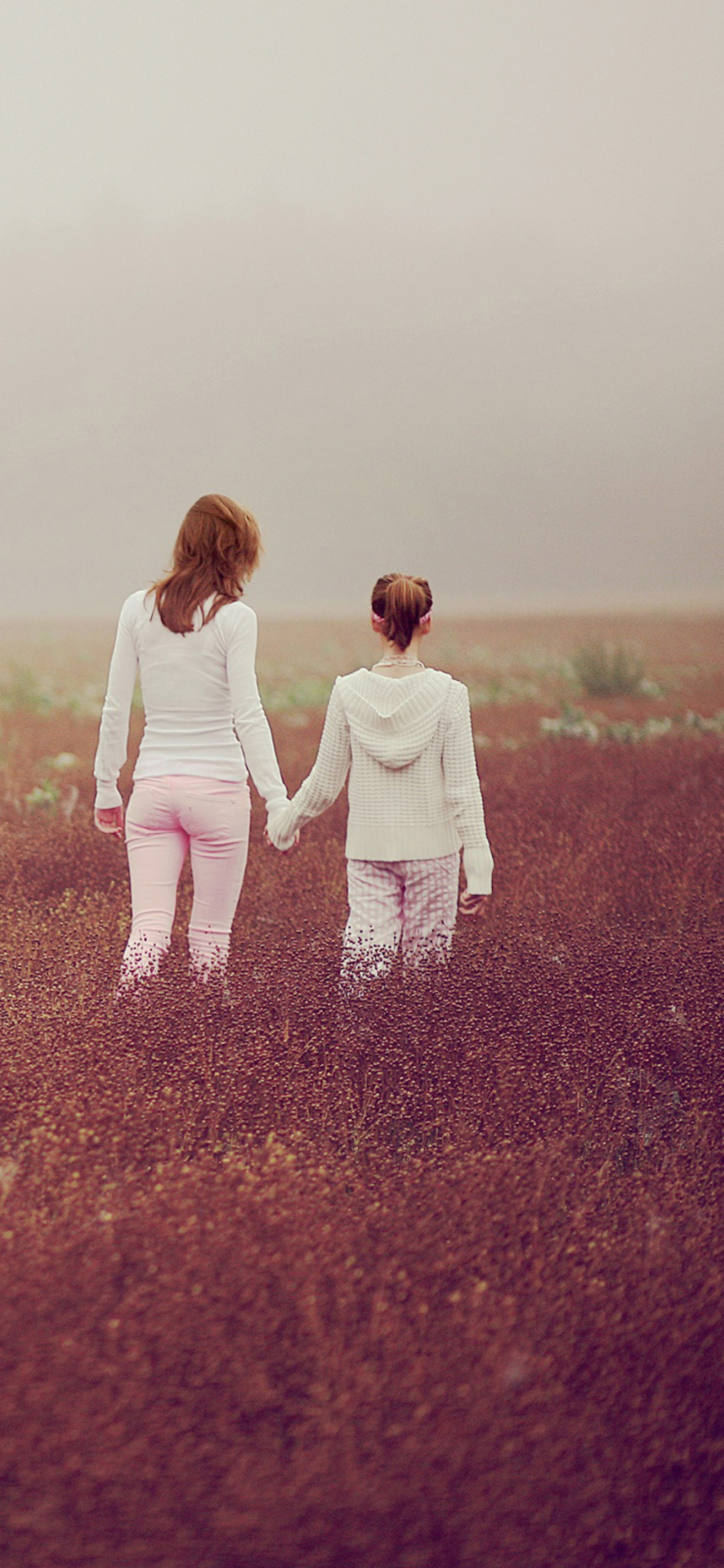 Two Girls Walking In The Field wallpaper 1170x2532