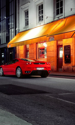 Das Red Ferrari In City Lights Wallpaper 240x400