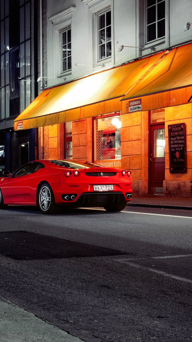 Das Red Ferrari In City Lights Wallpaper 750x1334
