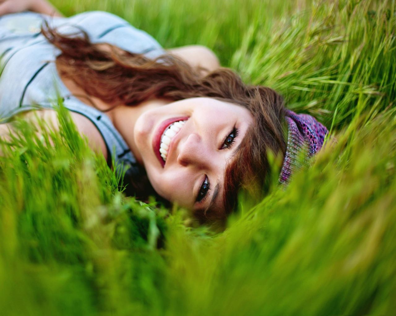 Fondo de pantalla Smiling Girl Lying In Green Grass 1280x1024