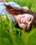 Smiling Girl Lying In Green Grass wallpaper 128x160