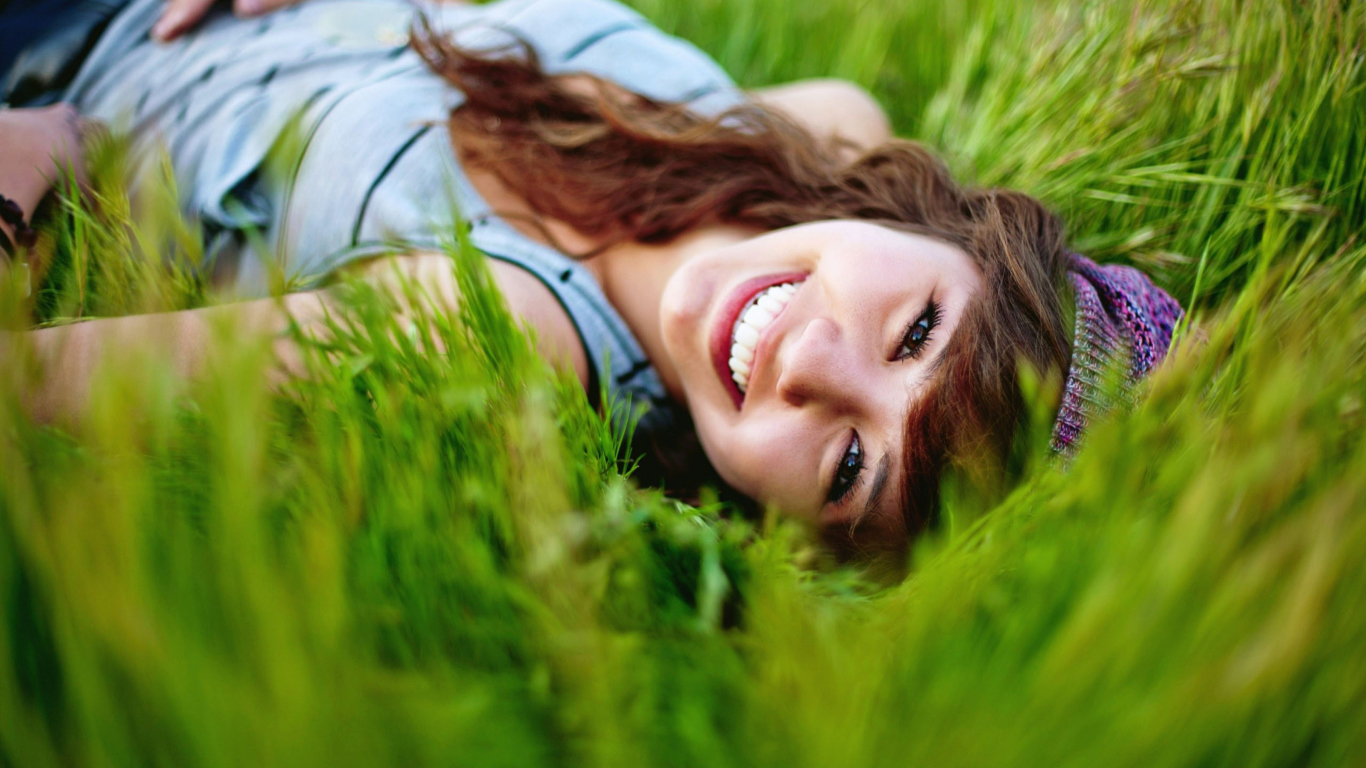 Fondo de pantalla Smiling Girl Lying In Green Grass 1366x768