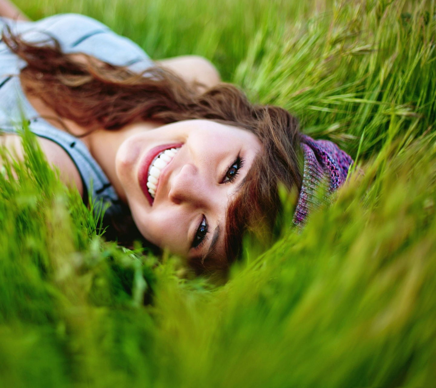 Das Smiling Girl Lying In Green Grass Wallpaper 1440x1280