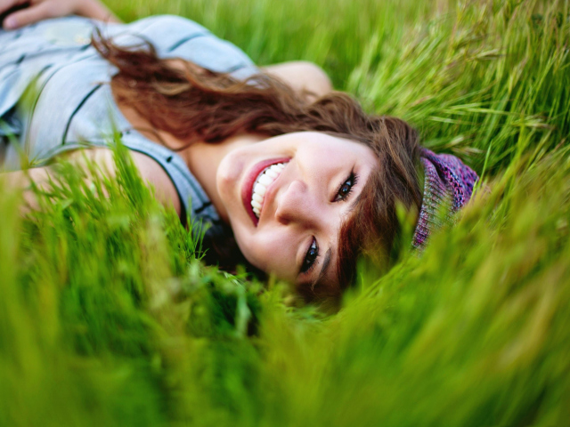 Das Smiling Girl Lying In Green Grass Wallpaper 640x480