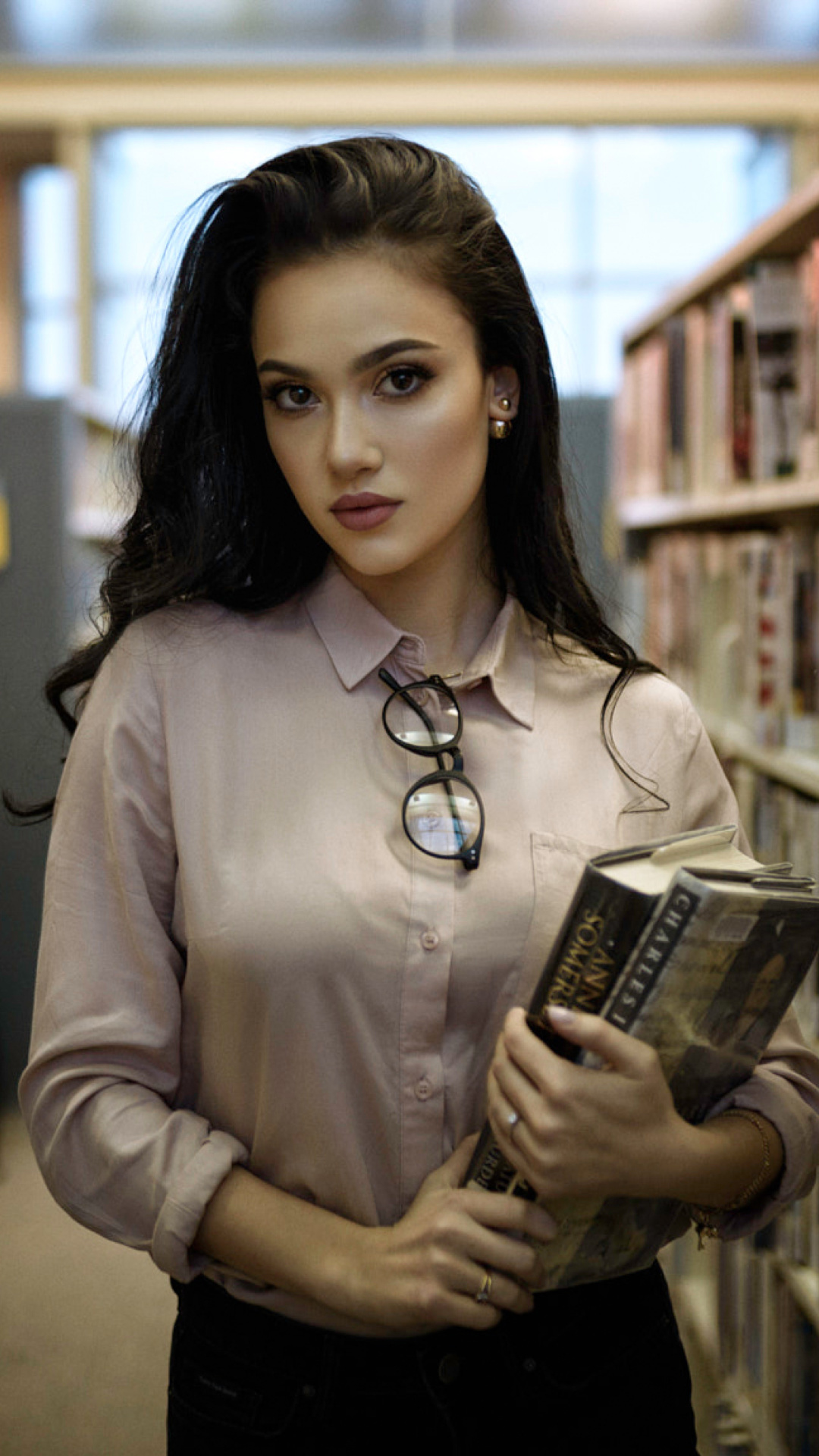 Fondo de pantalla Girl with books in library 1080x1920