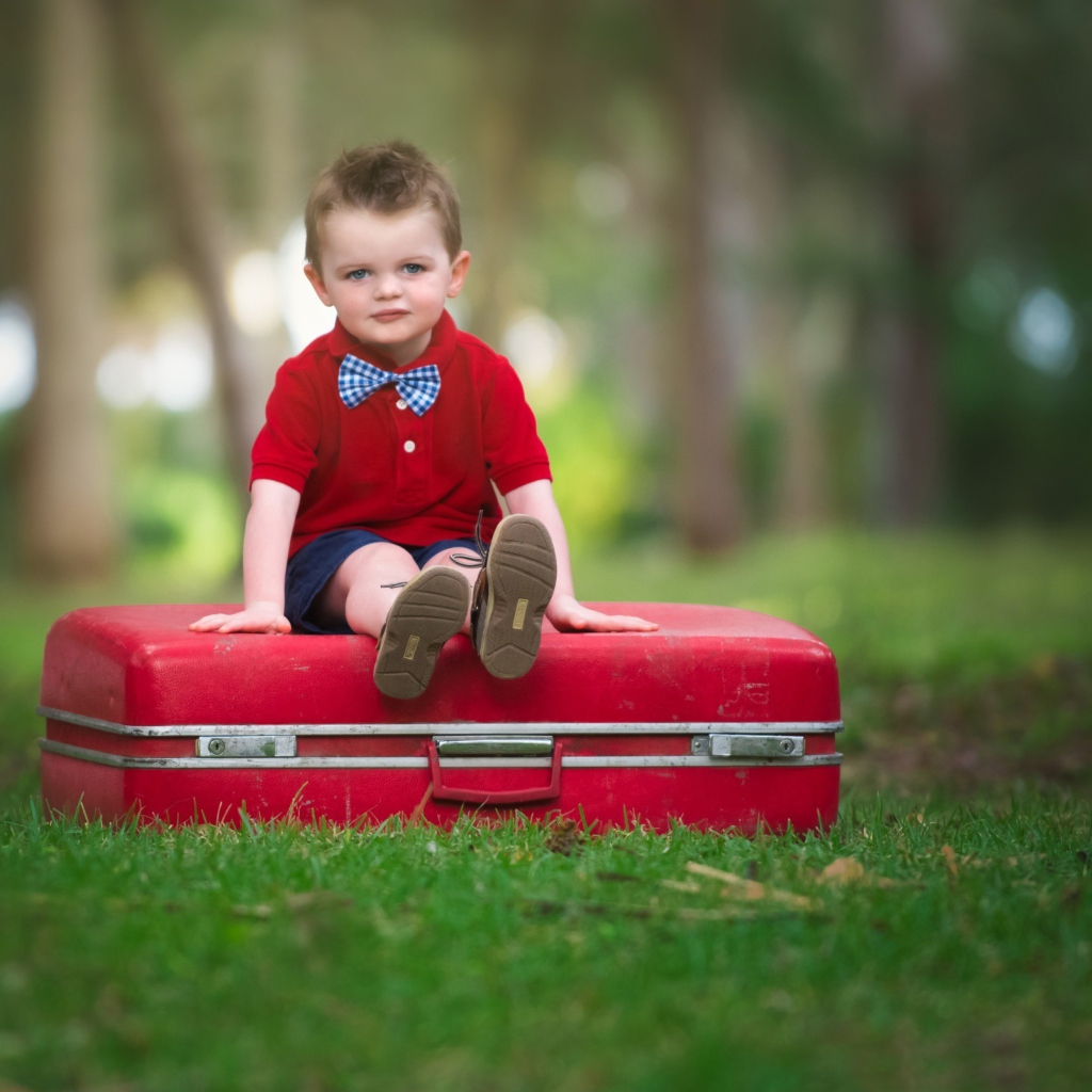 Das Cute Boy Sitting On Red Luggage Wallpaper 1024x1024