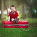 Cute Boy Sitting On Red Luggage wallpaper 128x128