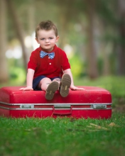 Обои Cute Boy Sitting On Red Luggage 176x220