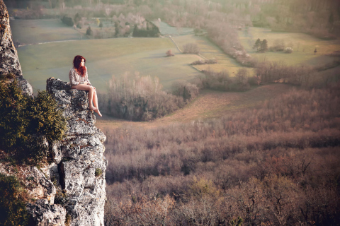 Обои Redhead Girl Sitting On Rock 480x320