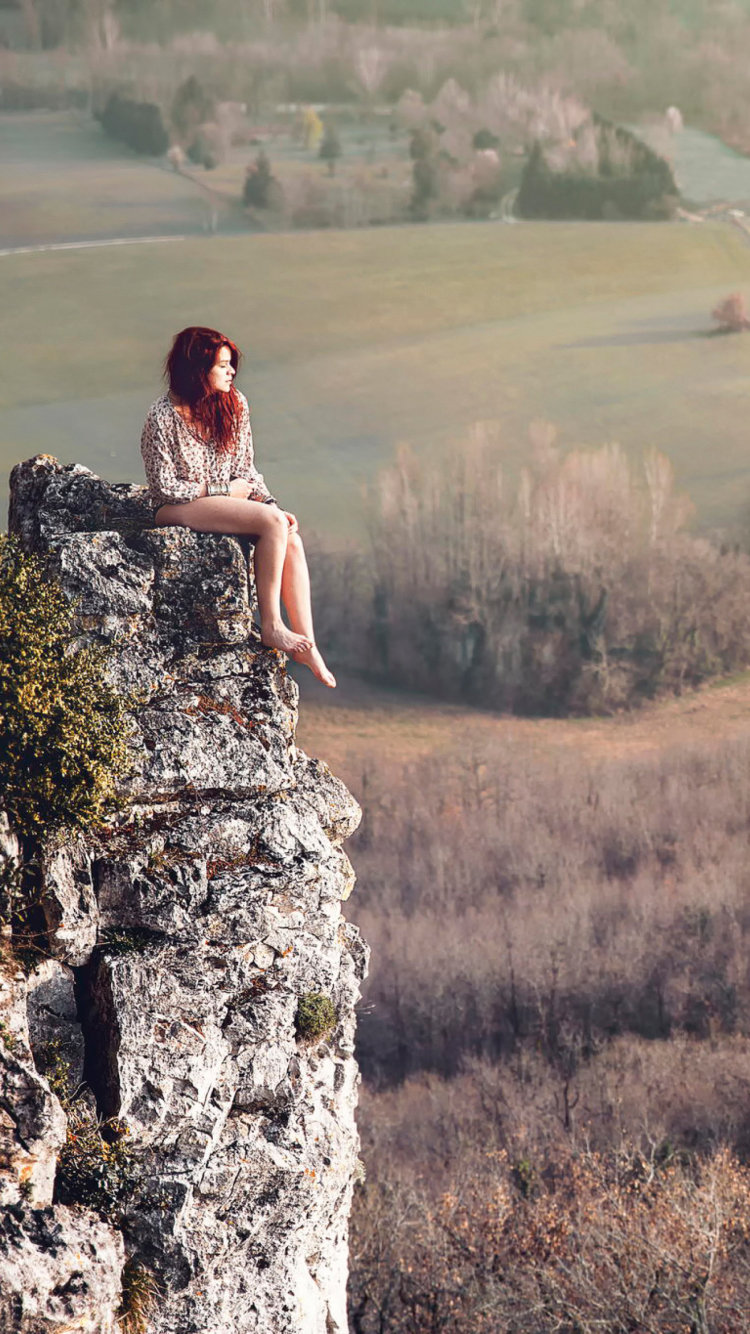 Обои Redhead Girl Sitting On Rock 750x1334
