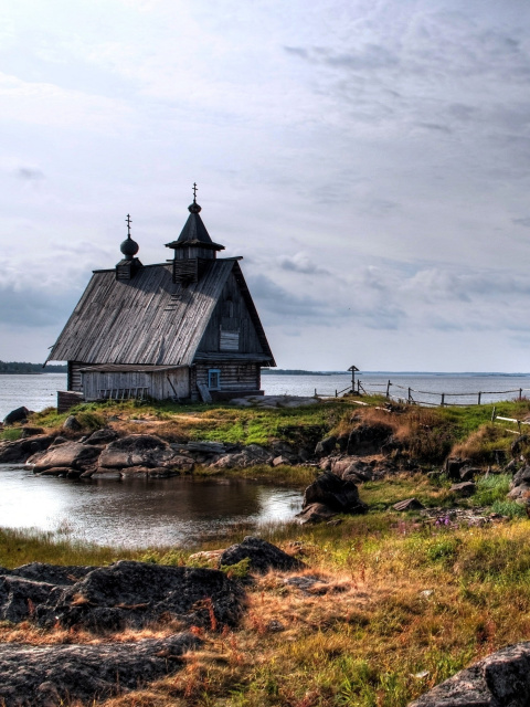 Das Old small house on the rocky river shore Wallpaper 480x640