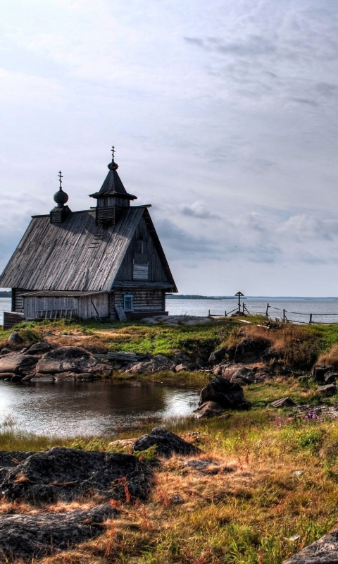 Old small house on the rocky river shore wallpaper 480x800