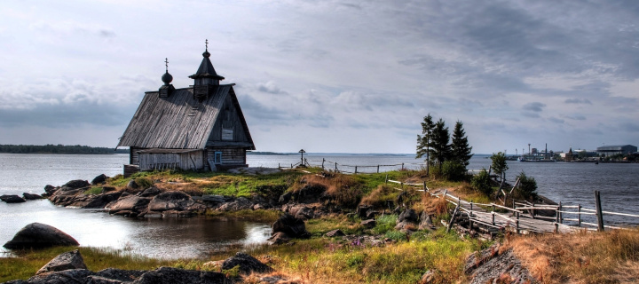 Old small house on the rocky river shore wallpaper 720x320