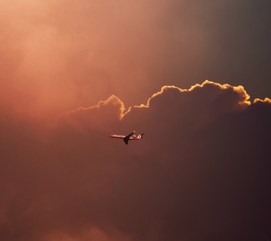 Das Airplane In Red Sky Above Clouds Wallpaper 1080x960