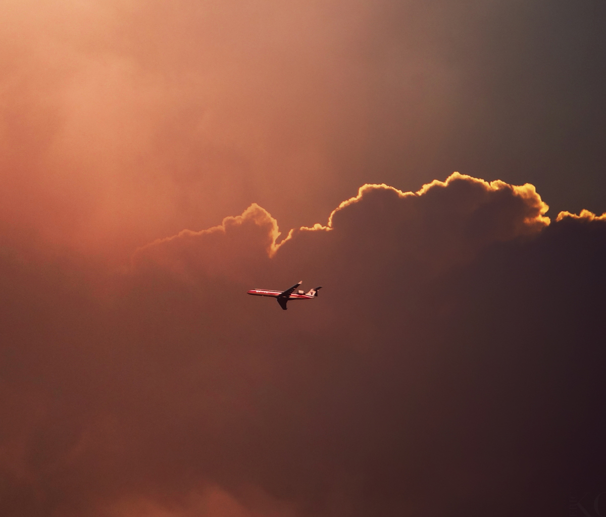 Fondo de pantalla Airplane In Red Sky Above Clouds 1200x1024