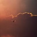 Airplane In Red Sky Above Clouds wallpaper 128x128