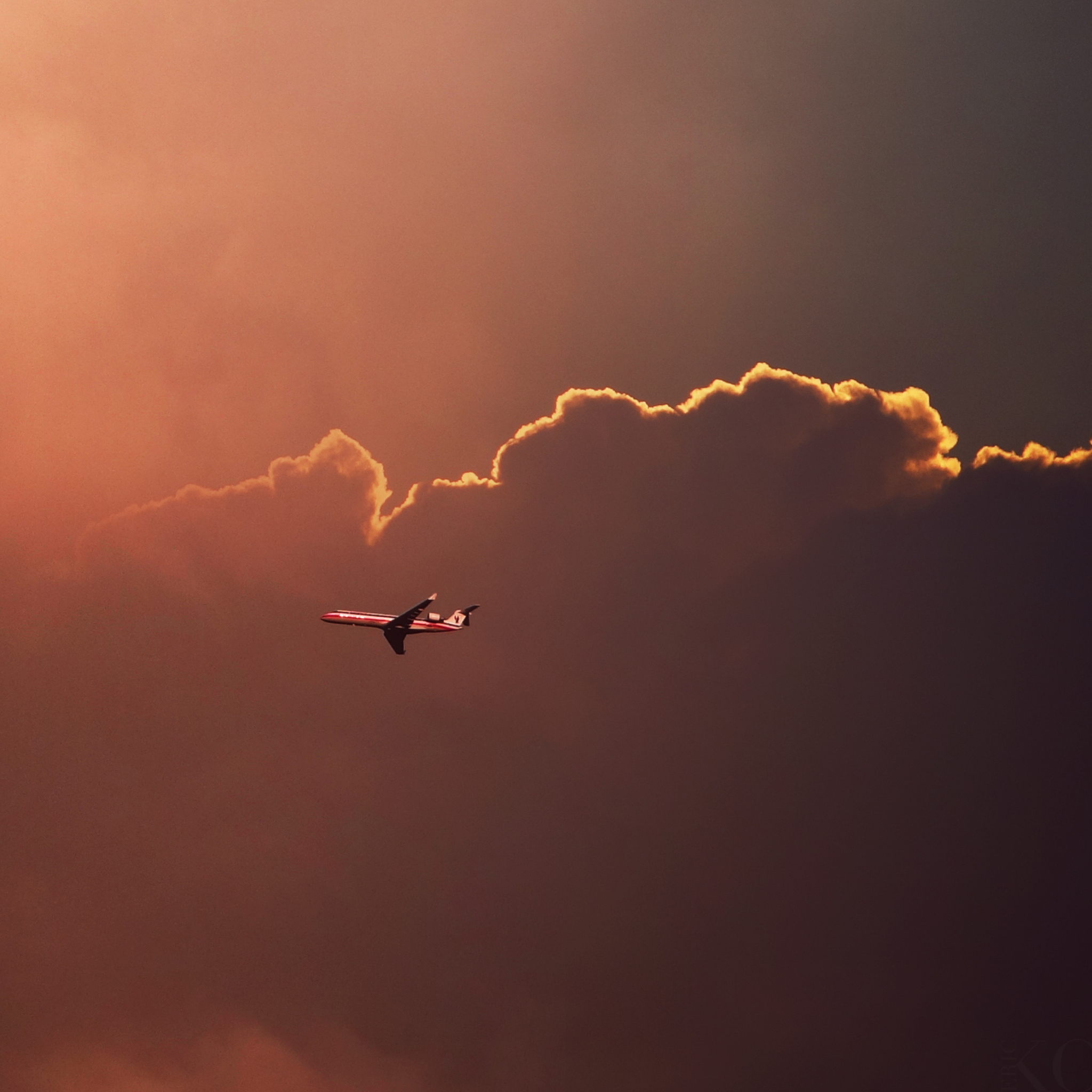 Airplane In Red Sky Above Clouds wallpaper 2048x2048