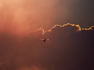 Das Airplane In Red Sky Above Clouds Wallpaper 320x240