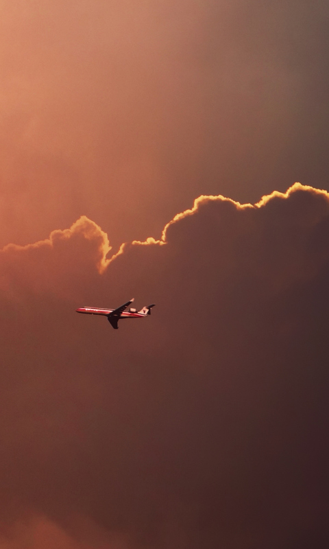 Fondo de pantalla Airplane In Red Sky Above Clouds 480x800