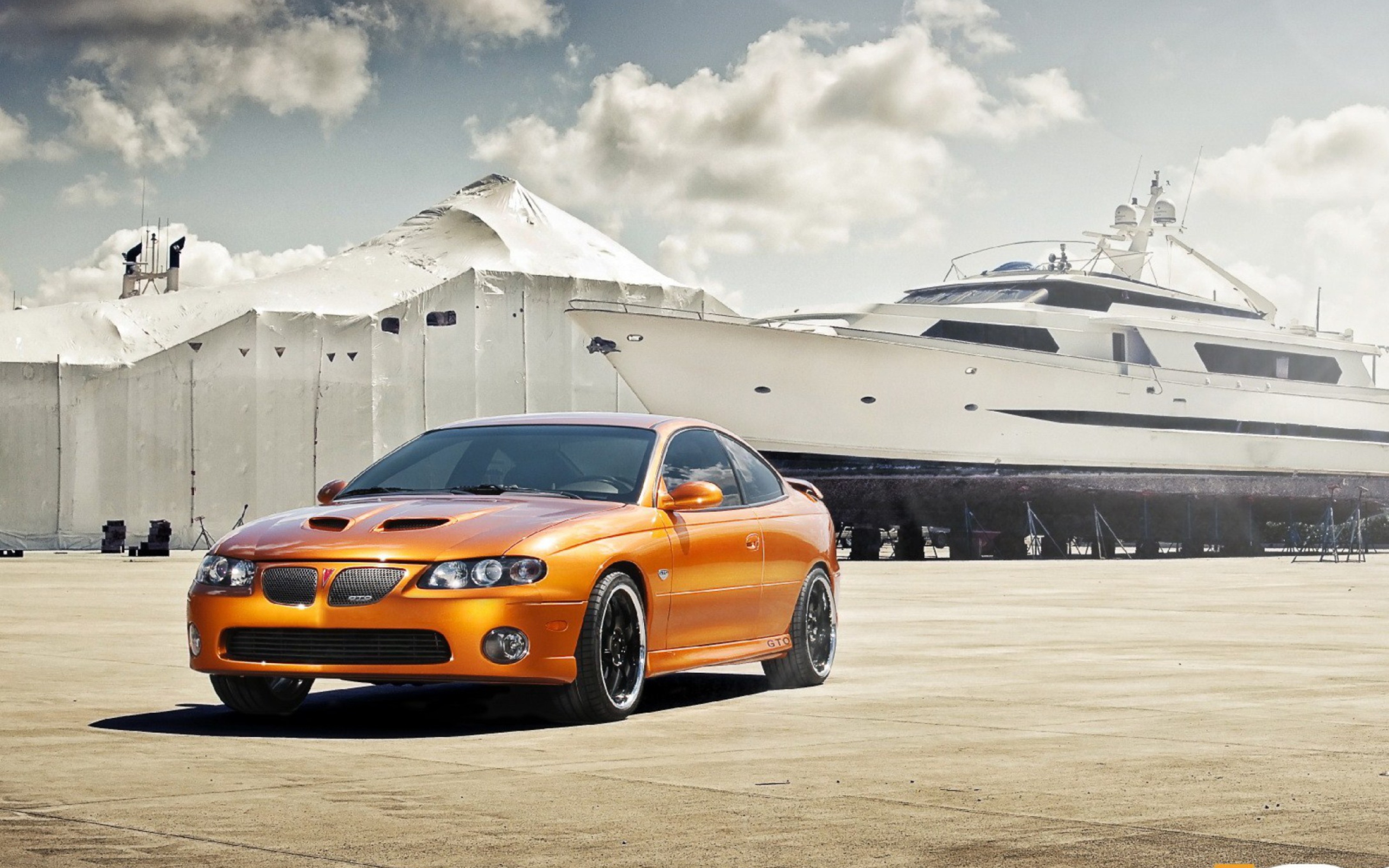 Обои Orange Pontiac GTO In Port Ship 2560x1600