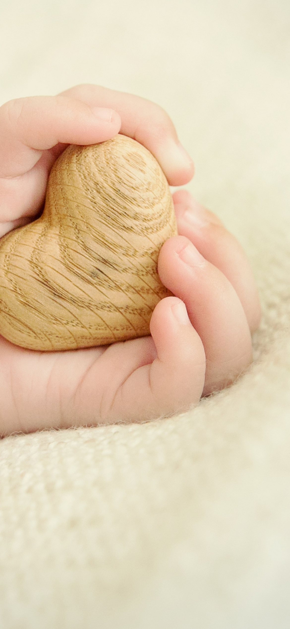 Little Wooden Heart In Child's Hands wallpaper 1170x2532