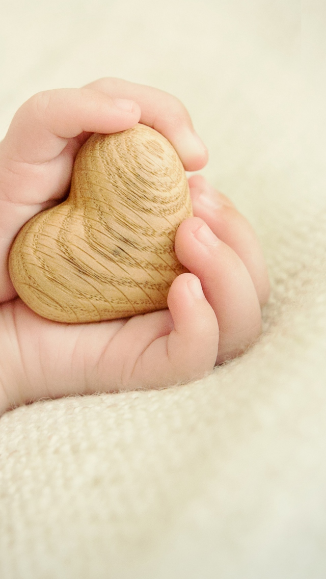 Fondo de pantalla Little Wooden Heart In Child's Hands 640x1136