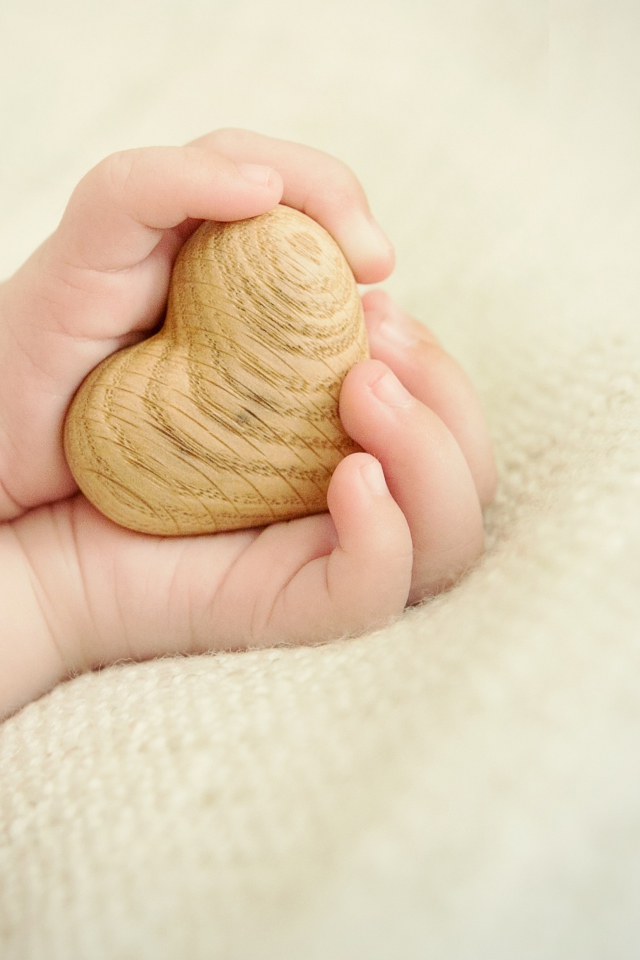 Little Wooden Heart In Child's Hands wallpaper 640x960