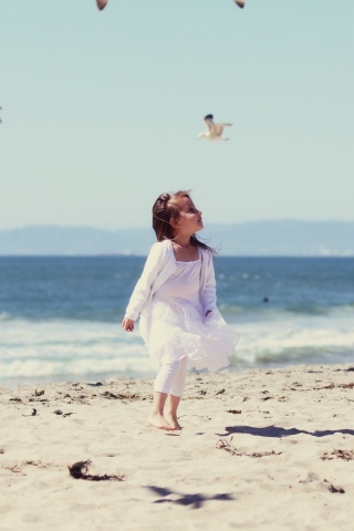 Sfondi Little Girl At Beach And Seagulls 320x480
