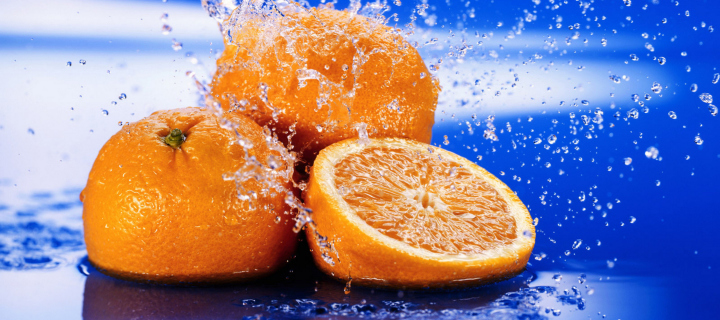 Sfondi Juicy Oranges In Water Drops 720x320